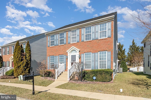 colonial-style house featuring brick siding, central AC, and a front lawn