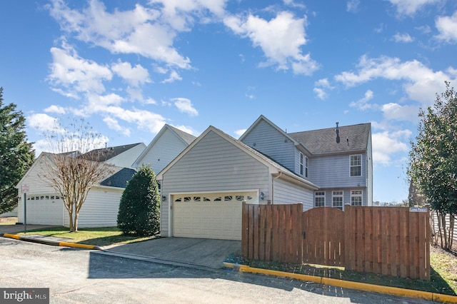 view of front facade featuring fence, driveway, and an attached garage