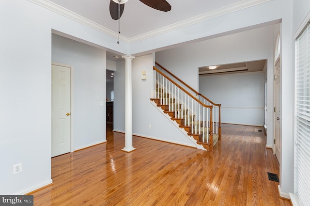 interior space featuring visible vents, stairway, ornamental molding, wood finished floors, and ornate columns