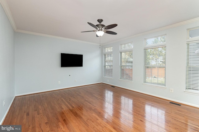 unfurnished living room featuring wood finished floors, a ceiling fan, visible vents, baseboards, and ornamental molding