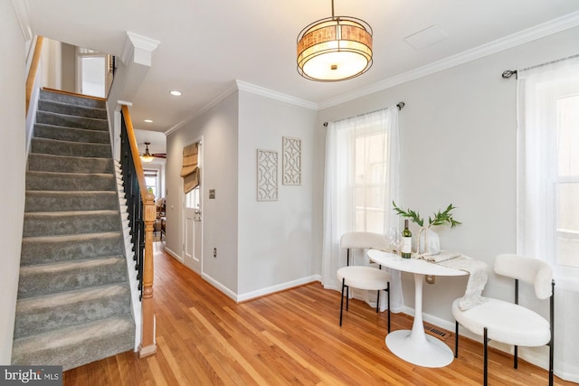 sitting room with baseboards, wood finished floors, stairs, crown molding, and recessed lighting