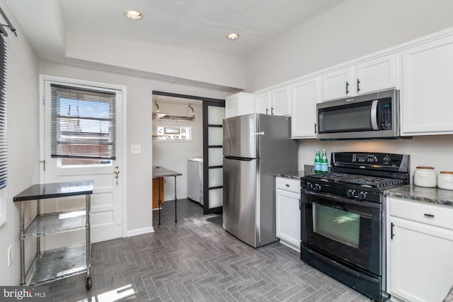 kitchen with baseboards, white cabinets, dark stone counters, stainless steel appliances, and recessed lighting