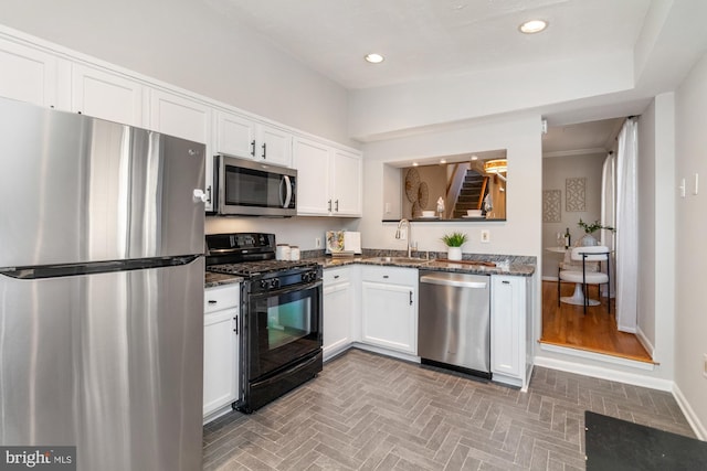 kitchen featuring white cabinets, stainless steel appliances, a sink, and recessed lighting