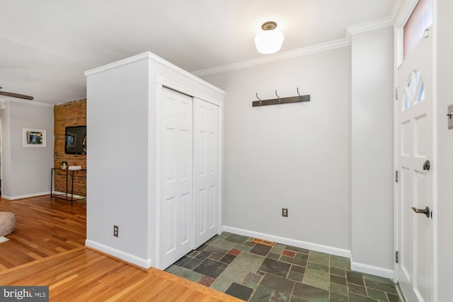 foyer with ceiling fan, baseboards, ornamental molding, and dark wood finished floors