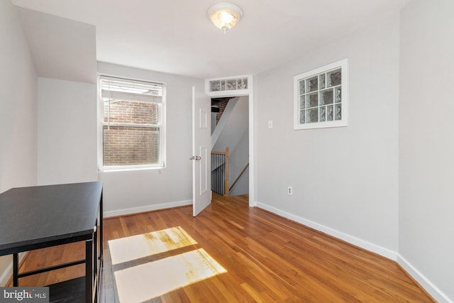 unfurnished bedroom with wood finished floors and baseboards