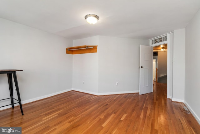 empty room featuring wood finished floors and baseboards