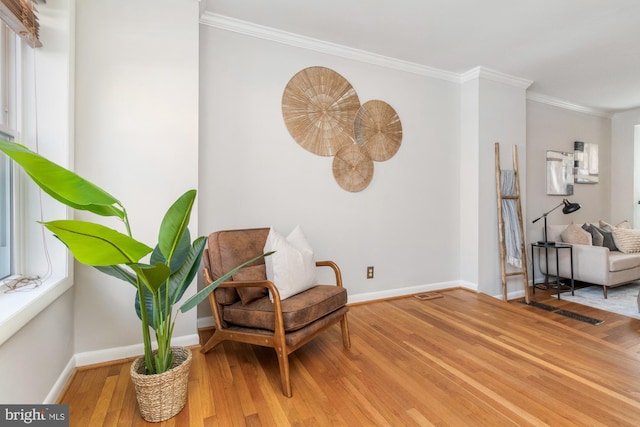 sitting room featuring crown molding, baseboards, and wood finished floors