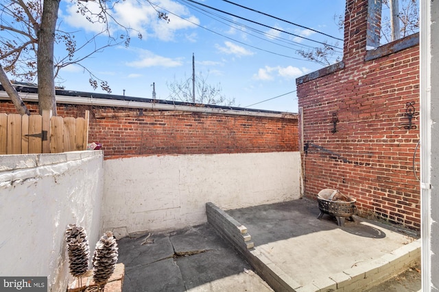 view of patio / terrace featuring fence and a fire pit