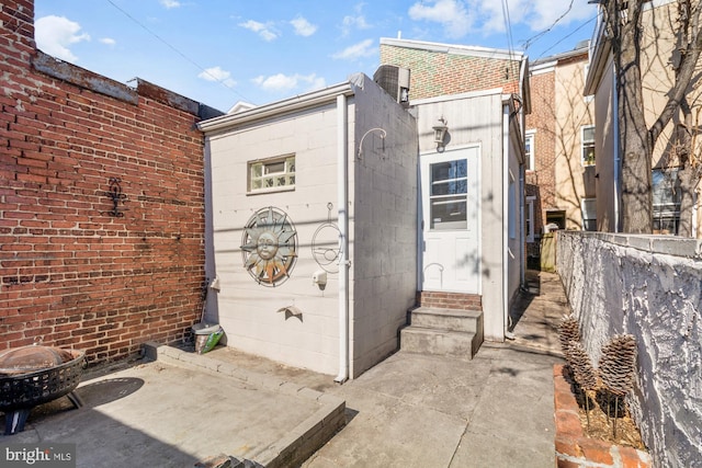 exterior space with brick siding and a patio