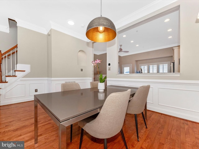 dining area featuring light wood-type flooring and crown molding