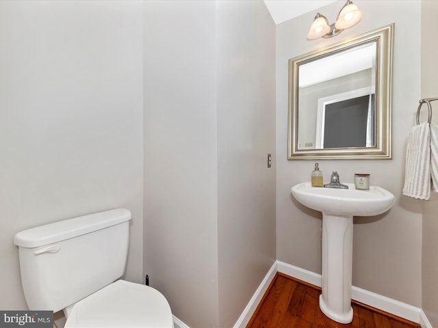 bathroom with hardwood / wood-style flooring and toilet