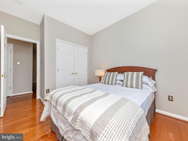 bedroom with light wood-type flooring and a closet