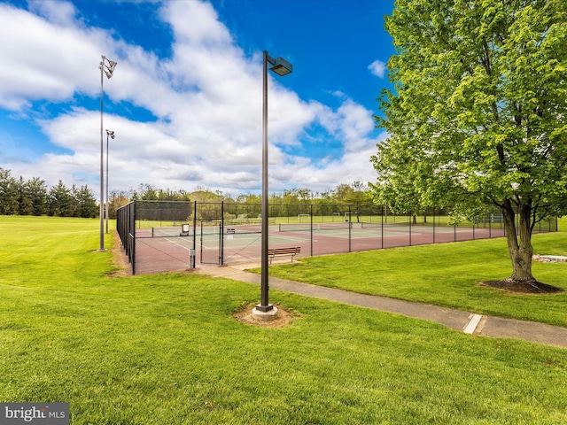 view of sport court with a lawn