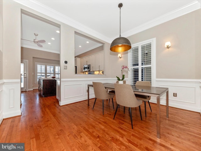 dining area with light wood-type flooring and crown molding