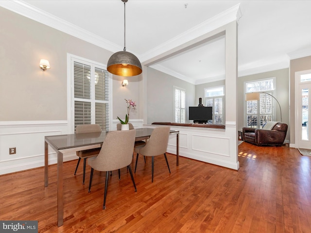 dining space with hardwood / wood-style flooring and crown molding