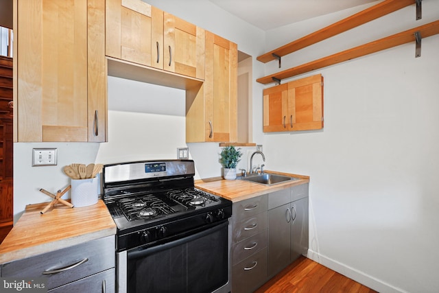 kitchen with light countertops, a sink, open shelves, and gas range oven