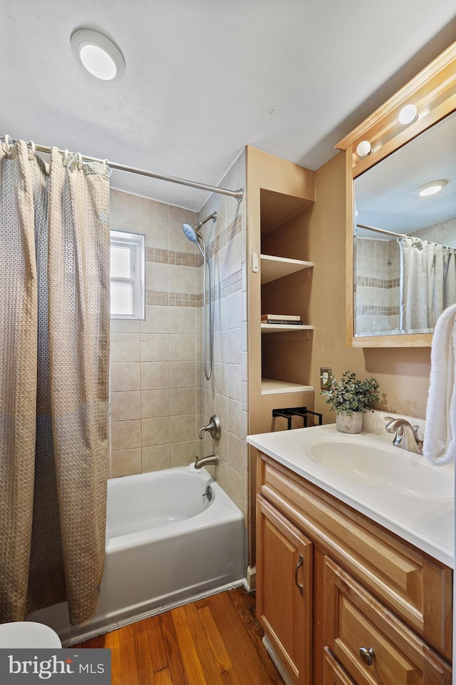 full bath with shower / bath combination with curtain, wood finished floors, and vanity