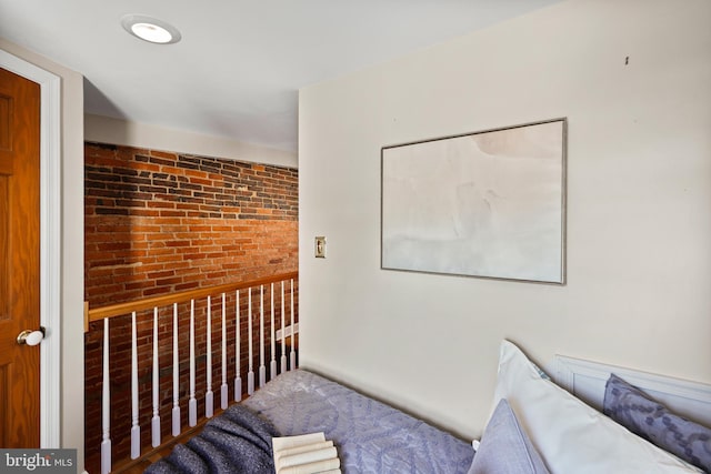 unfurnished bedroom featuring brick wall