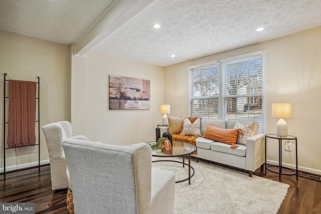 living room with a textured ceiling, recessed lighting, wood finished floors, and baseboards