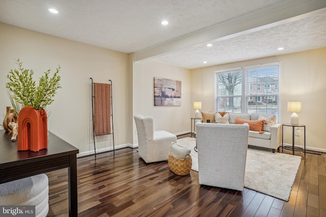 living room featuring baseboards, wood finished floors, a textured ceiling, beam ceiling, and recessed lighting