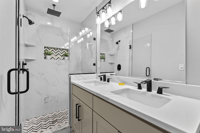 full bathroom featuring a sink, a marble finish shower, and double vanity