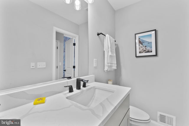 bathroom with visible vents, vanity, and toilet