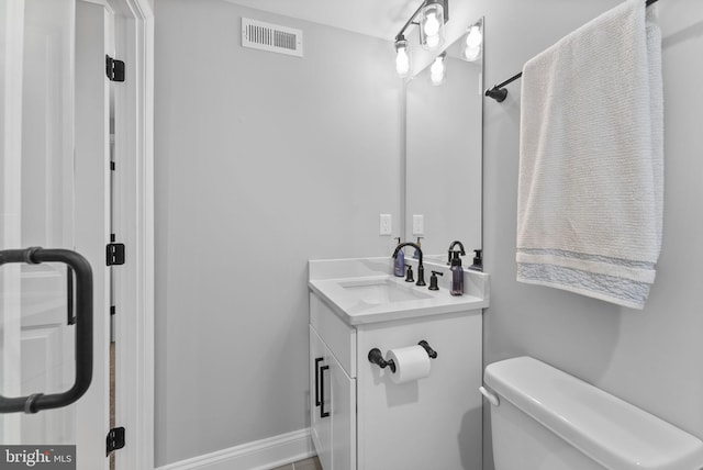 bathroom with toilet, baseboards, visible vents, and vanity