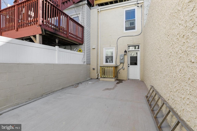 back of house featuring brick siding, a patio, and fence