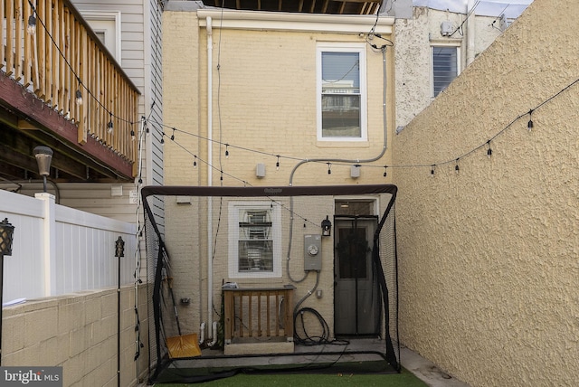 exterior space featuring brick siding and fence