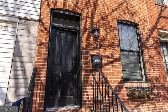 doorway to property featuring brick siding