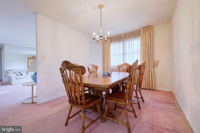 dining space with light carpet, baseboards, and a notable chandelier