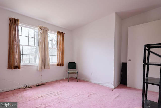 spare room featuring carpet floors, visible vents, and baseboards