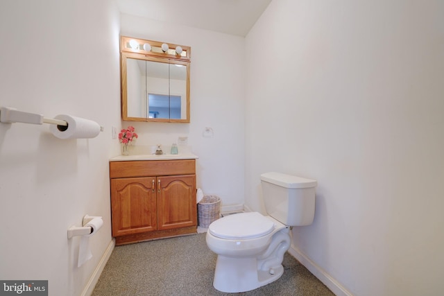 half bathroom with toilet, baseboards, and vanity