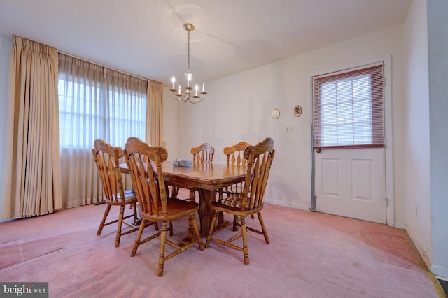 dining area with light carpet, a chandelier, and baseboards