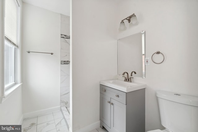 full bath featuring marble finish floor, baseboards, vanity, and toilet