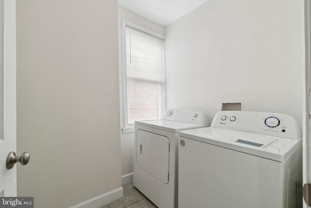 laundry room featuring light tile patterned floors, laundry area, washing machine and clothes dryer, and baseboards