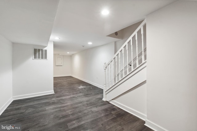 finished basement featuring baseboards, visible vents, dark wood-type flooring, and recessed lighting