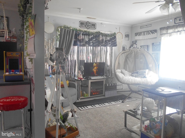 interior space featuring ceiling fan, ornamental molding, and carpet floors