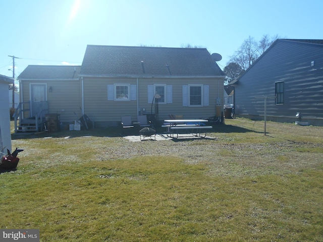 rear view of property featuring a lawn