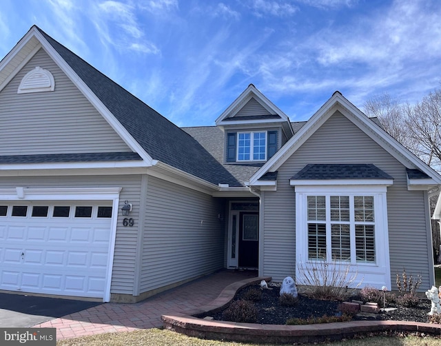 view of front of home featuring roof with shingles and an attached garage