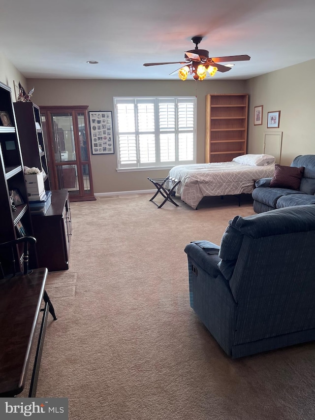 bedroom featuring baseboards, a ceiling fan, and light colored carpet