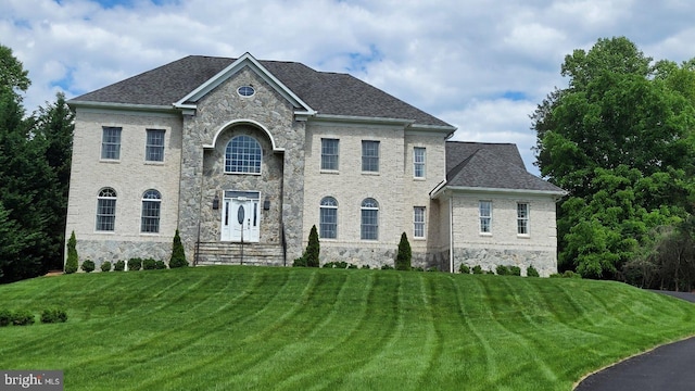 view of front of home featuring a shingled roof and a front lawn