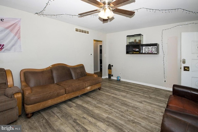 living room with a ceiling fan, wood finished floors, visible vents, and baseboards