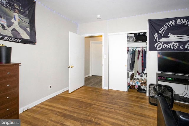 bedroom featuring a closet, baseboards, and wood finished floors