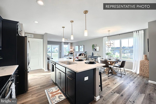 109 Weston Cir Lot 86, Duncannon, PA 17020 - kitchen with a kitchen island with sink, sink, light stone counters, hardwood / wood-style floors, and pendant lighting