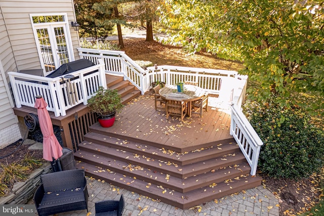 wooden terrace with outdoor dining space and stairway