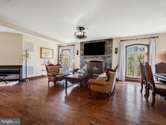 living area with plenty of natural light, a fireplace, and visible vents