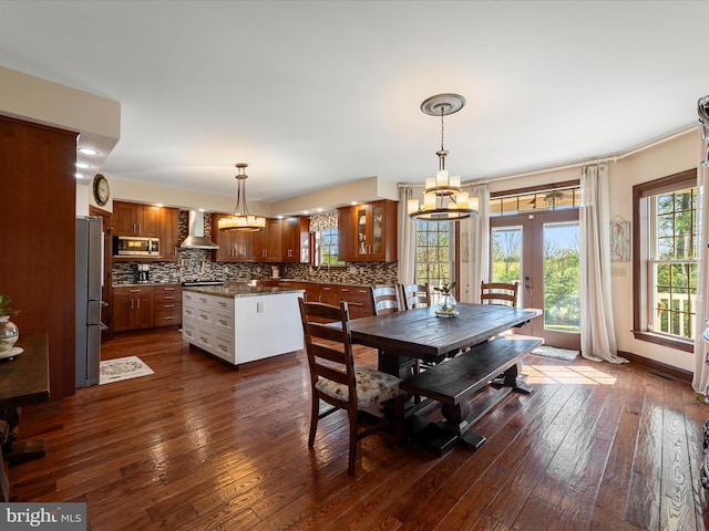 dining area featuring french doors, dark wood-style flooring, and a notable chandelier