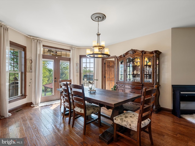 dining room with french doors, visible vents, dark wood finished floors, baseboards, and a chandelier