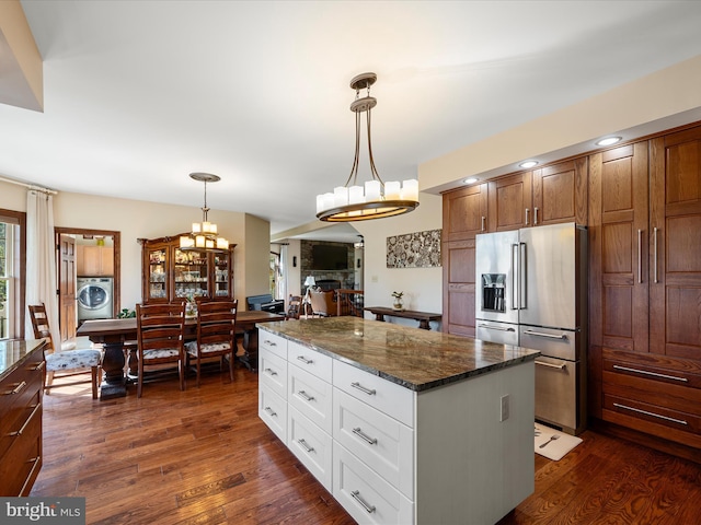 kitchen with dark wood-style flooring, washer / clothes dryer, a notable chandelier, and high quality fridge
